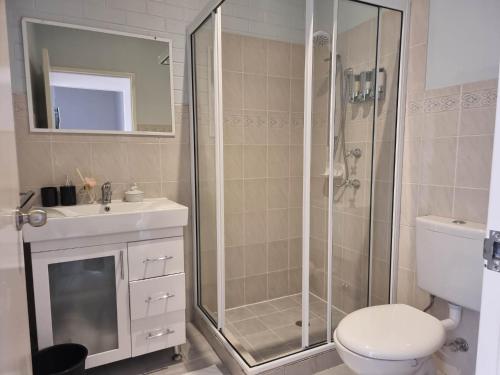 a bathroom with a shower and a toilet and a sink at Tuggeranong Short Stay #07 - Sleeps 6 in Tuggeranong