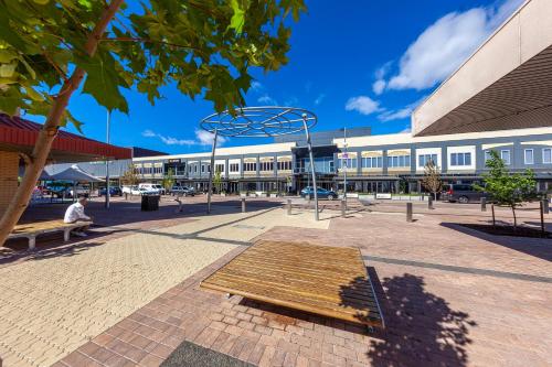 a bench in a plaza in front of a building at Tuggeranong Short Stay #07 - Sleeps 6 in Tuggeranong