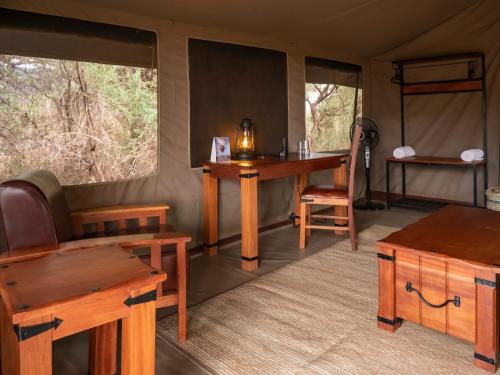 Tulia Amboseli Safari Camp في أمبوسيلي: غرفة مع طاولة وكرسي ومكتب