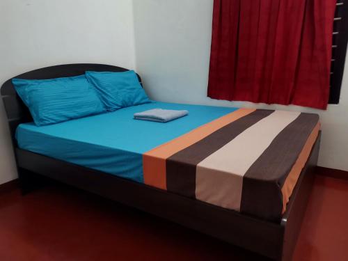 a bed in a room with a red window at Nallur Holidays Inn in Jaffna