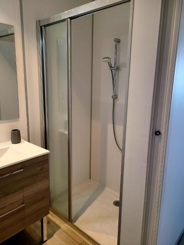 une douche avec une porte vitrée dans une salle de bain dans l'établissement Chambres d'hôte ROUQUART, à Méjannes-le-Clap