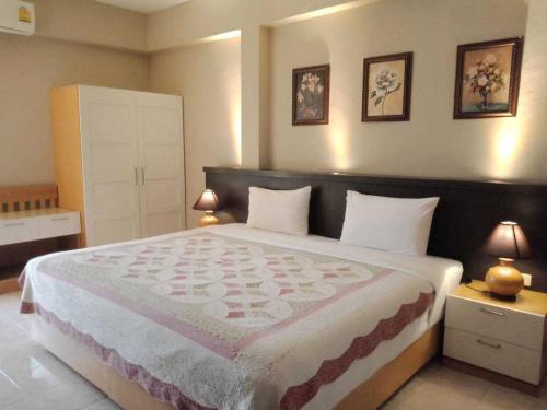 a bedroom with a large bed with two lamps at Rommai Greenpark in Lampang