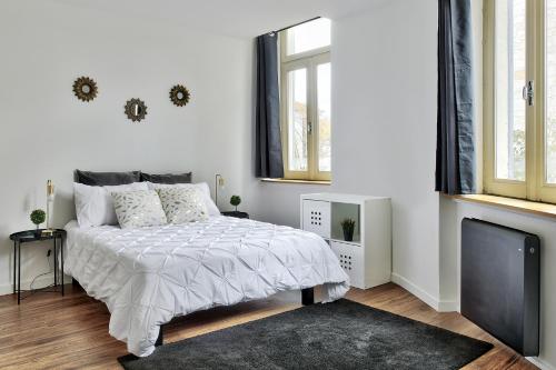 a white bedroom with a bed and a flat screen tv at Appartement Le Somptueux Bressan - Hyper-Centre in Bourg-en-Bresse