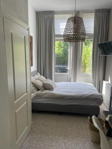a bedroom with a bed in front of a window at De Boetz in The Hague