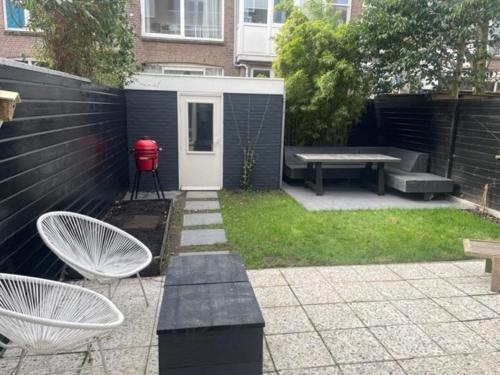un patio trasero con una mesa de picnic y un banco en De Boetz, en La Haya