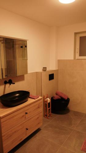 a bathroom with a black sink on a wooden counter at Apartment Dicka in Alpbach