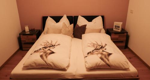 a bed with two deer pillows on it at Apartment Dicka in Alpbach