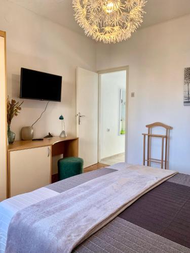 a bedroom with a large bed and a chandelier at Seafront Apartment Jadri in Umag