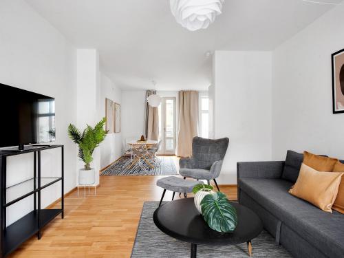 a living room with a couch and a table at Constantin - Chic 2-Bdr Apt with Balcony in Copenhagen
