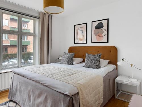 a bedroom with a large bed and a window at Sanders Constantin - Chic Two-Bedroom Apartment With Balcony in Copenhagen