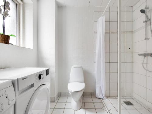 a white bathroom with a toilet and a shower at Sanders Constantin - Chic Two-Bedroom Apartment With Balcony in Copenhagen