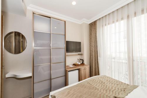 a hotel room with a bed and a television at Alphonse Hotel in Istanbul
