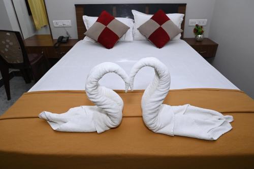 a bed with two swans shaped towels on it at HOTEL COSTA LAND in Port Blair