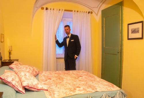 a man in a suit is standing in a window at La Foresteria del Passeggere in Ovada