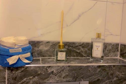 a shelf with three bottles of soap and a wand at شقق المملكة in Bursa