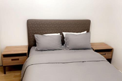 a bed with two nightstands and two pillows at شقق المملكة in Bursa
