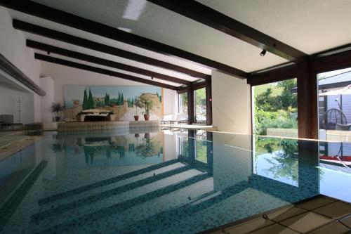 a swimming pool in a house with a glass floor at FeWo Glockenstüble mit Schwimmbad und Sauna in Oberstaufen