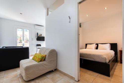 ein Schlafzimmer mit einem Bett, einem Stuhl und einem Spiegel in der Unterkunft Nice apartment in Gracia in Barcelona