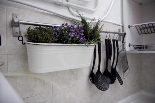una olla de flores y utensilios colgando en una pared en A Casa di Irene, en Como