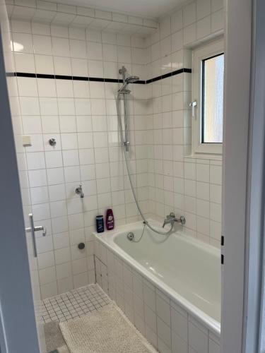 a bathroom with a bath tub and a window at Apartment Meditari Bonn-Muffendorf in Bonn