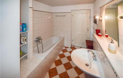 a white bathroom with a tub and a sink at Ferienwohnung Niederndorferb in Niederndorferberg