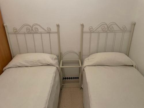 克莉絲蒂娜島的住宿－Piso Isla Cristina Punta del Caimán，两张睡床彼此相邻,位于一个房间里