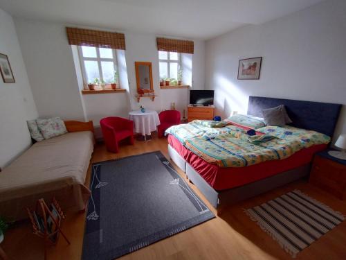 a bedroom with a bed and a couch and a table at Penzión Evka in Poprad