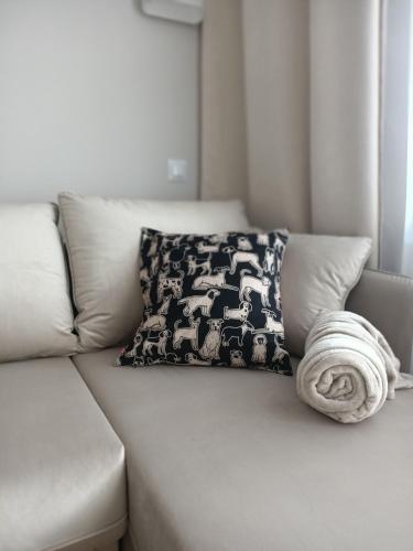 a black and white pillow on a white couch at Apartament Emili VIPOO in Suwałki