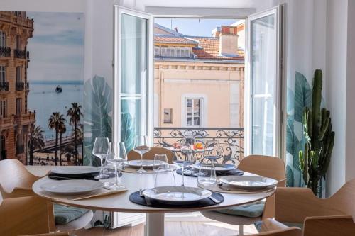 une salle à manger avec une table et une grande fenêtre dans l'établissement Luxury Apt With Balcony On Famous Rue D'antibes! - Kiss Apartment by Halldis, à Cannes