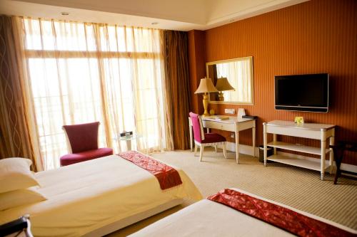 Tempat tidur dalam kamar di Suning Universal Hotel