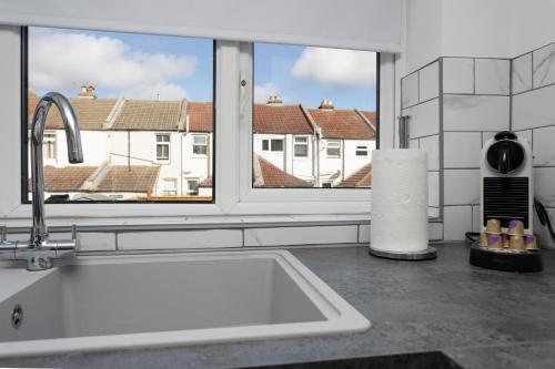 a kitchen with a sink and a large window at Methuen Mews - 2 double bedroom townhouse within walking distance to beach, on-street parking in Portsmouth in Portsmouth