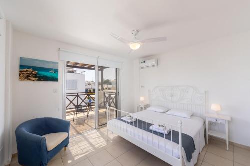 een slaapkamer met een bed en een stoel en een balkon bij Protaras Sapphire Seaside Villa in Protaras