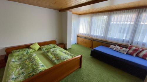 1 dormitorio con cama, sofá y ventana en Ferienwohnung Kaufmann, en Oberstaufen