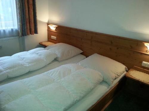 two beds with white pillows in a room at Ferienwohnung Mack in Oberstaufen