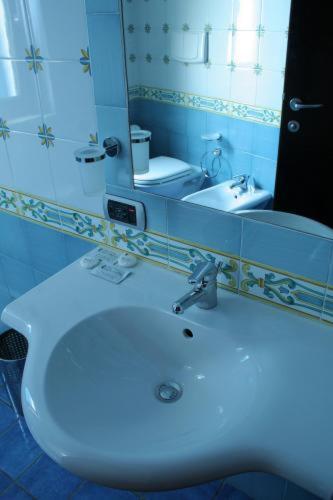 a bathroom with a white sink and a mirror at Hotel La Lucertola in Vietri sul Mare