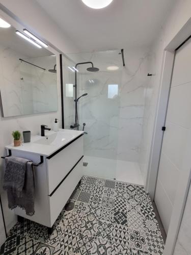 ein weißes Bad mit einem Waschbecken und einer Dusche in der Unterkunft Terraza Almería in Almería