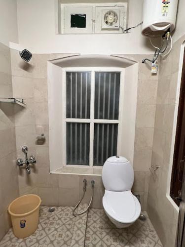 a small bathroom with a toilet and a window at Raasa Veedu in Settūr