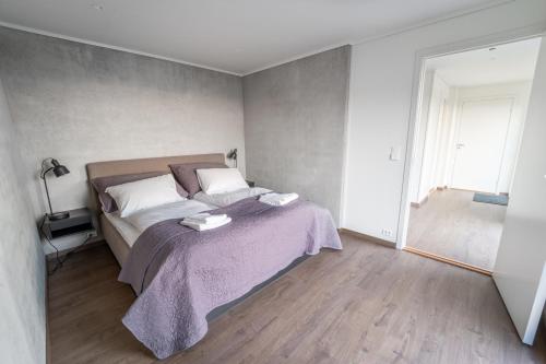 1 dormitorio con 1 cama con manta morada en Runde Panorama - Ørneredet, en Runde