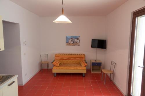 a living room with a couch and a tv at Case Vacanze Uliveto in Mattinata