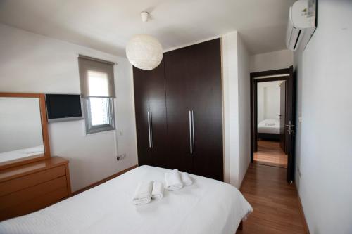 a bedroom with a white bed with two towels on it at Glabur Stays - The Executive 2 BDR - Nicosia City, Free Parking & Wifi, Welcomes You!!! in Nicosia