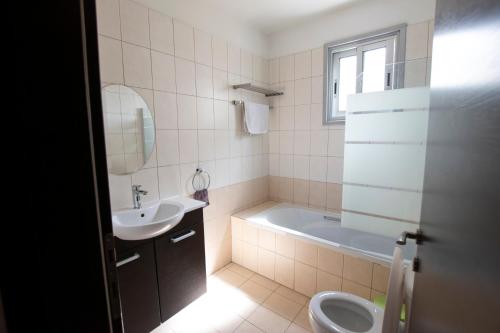 y baño con bañera, lavabo y aseo. en Glabur Stays - The Executive 2 BDR - Nicosia City, Free Parking & Wifi, Welcomes You!!!, en Nicosia