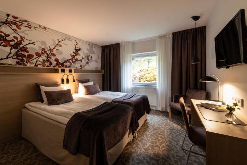 Cette chambre comprend un lit et un bureau. dans l'établissement Bosön Hotell & Konferens, à Lidingö