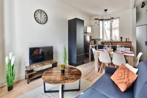a living room with a blue couch and a table at Appartement Le Chaleureux Chalon - Hyper-Centre in Chalon-sur-Saône