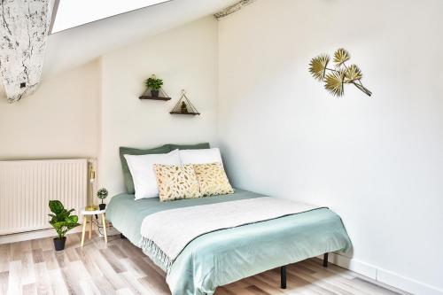 a bedroom with a bed with white walls at Appartement Le Chaleureux Chalon - Hyper-Centre in Chalon-sur-Saône