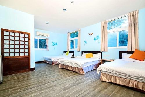 南庄的住宿－毓琇圖書山莊，配有两张床铺的蓝色墙壁和窗户