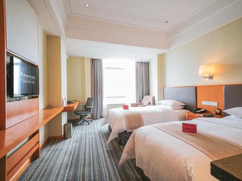 a hotel room with two beds and a flat screen tv at Ramada Plaza Shanghai Pudong Airport - 3 mins to PVG depature floor & check entrance with hotel shuttle in Shanghai