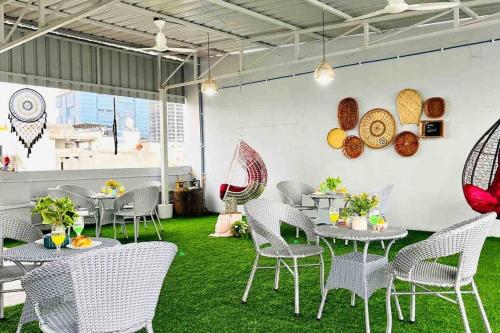 a restaurant with tables and chairs on green grass at BluO Studio Gachibowli - Terrace Garden, Lift in Hyderabad