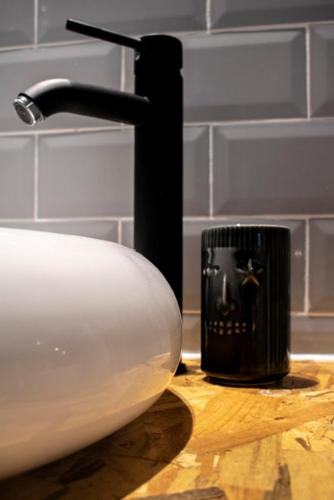 a bathroom sink with a black candle on a counter at Casa Mas Montañas - Gris in Godelleta