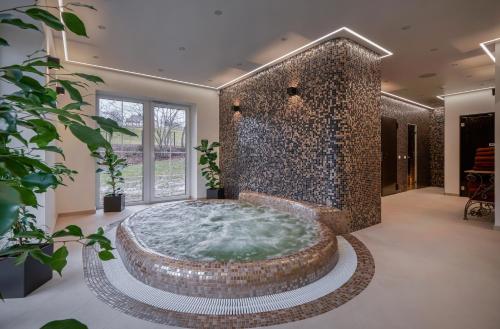 um quarto grande com uma grande banheira com uma parede de pedra em Jonavos alpakų svečių namai em Jonava