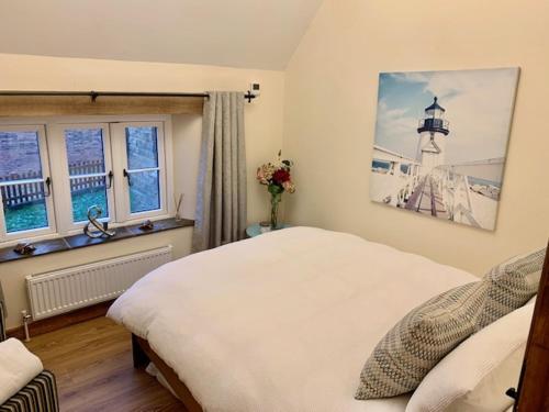 1 dormitorio con 1 cama blanca grande y 2 ventanas en Denbrae, en Brackley